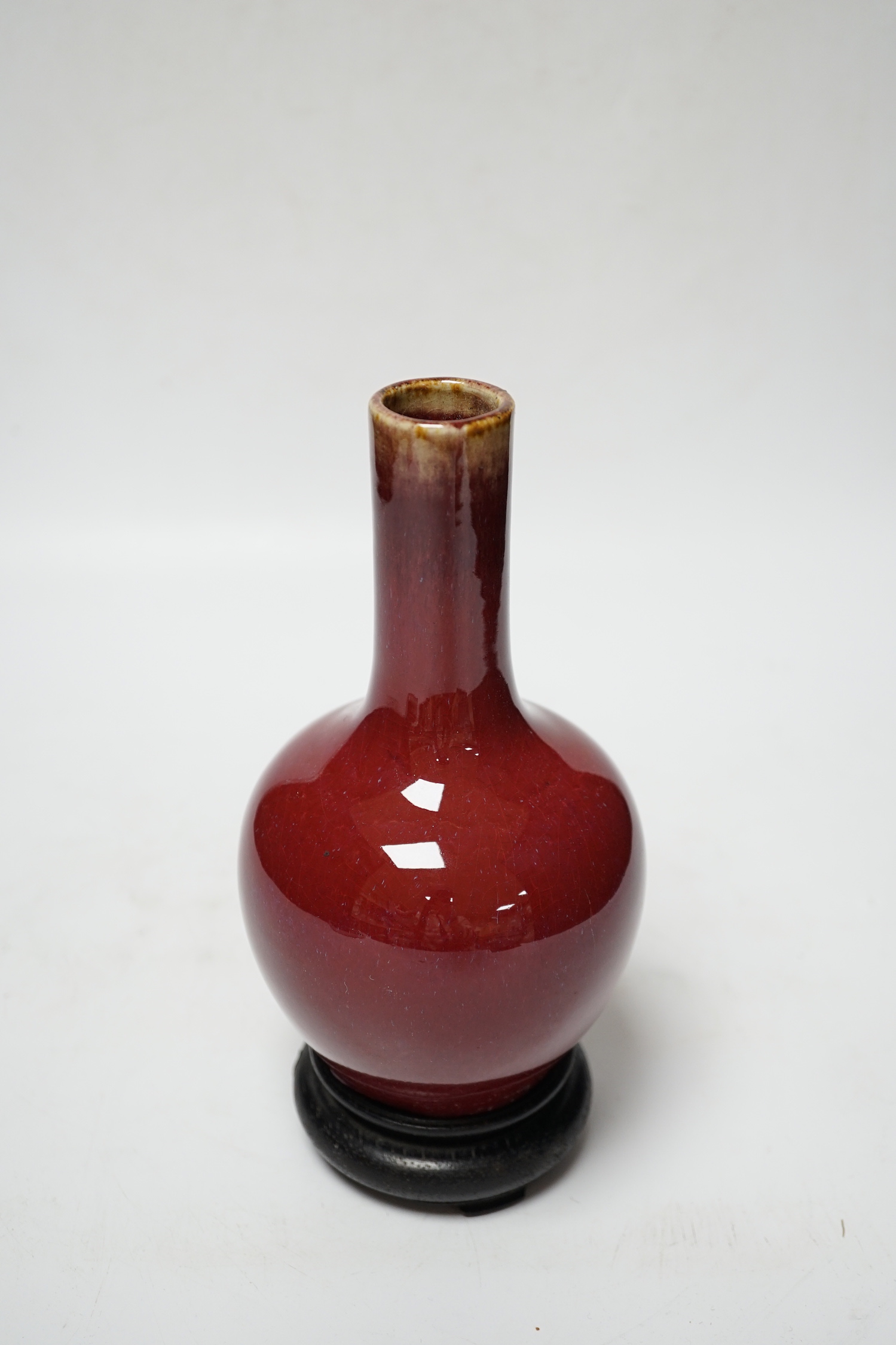 A small Chinese sang de boeuf glazed vase and stand 22cm high including stand